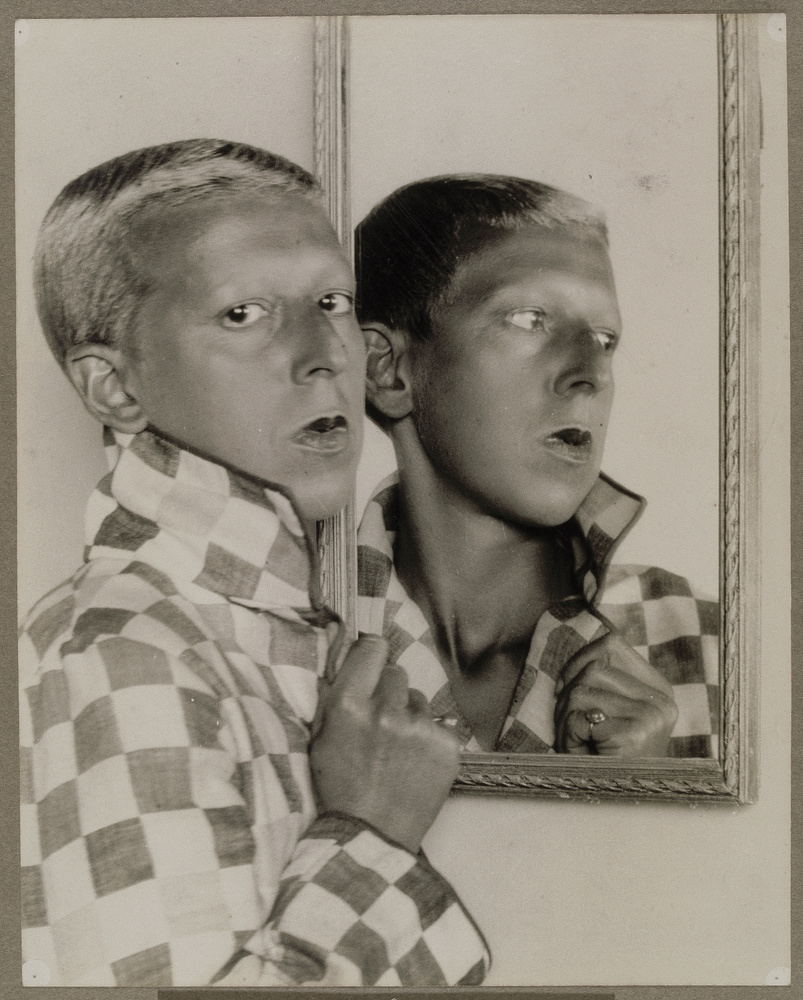 Autoportrait de Claude Cahun tenant un miroir qui dédouble son visage
